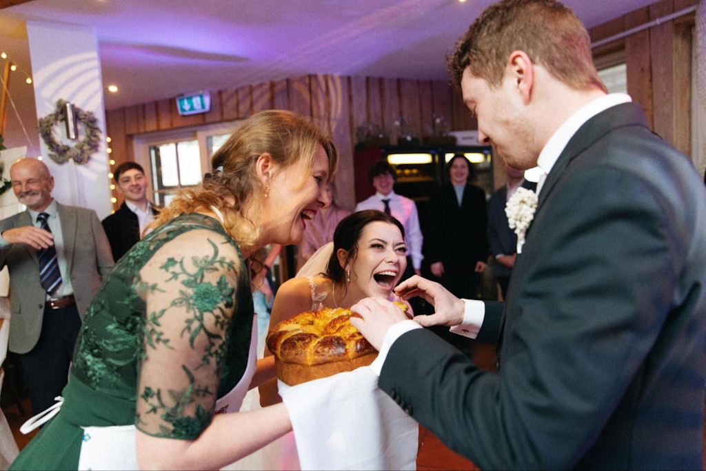 Braut und Brautmutter beim Brot-und-Salz-Ritual mit Karawai bei einer russischen Hochzeit